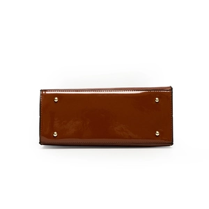 Brown patent leather tote base with four gold metal protective feet and stitching