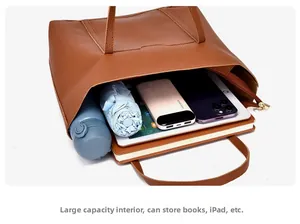 Interno spazioso della borsa tote in pelle marrone con iPad, ombrello e vari quaderni