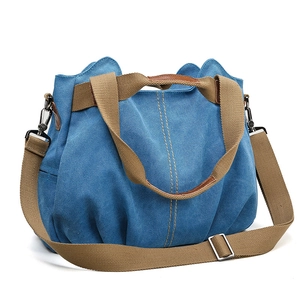 Minimalist navy canvas tote bag with contrast orange stitching and brown shoulder strap