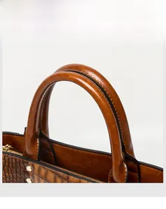 Détail du sac à main marron motif crocodile avec poignées robustes et rivets dorés