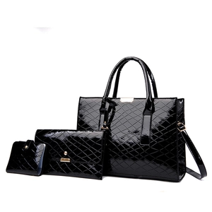 Detailansicht des schwarzen glänzenden Taschensets mit Rautensteppung und goldenen Beschlägen