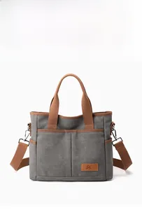 Sac fourre-tout en toile grise avec poignées marron et écusson logo en cuir poli