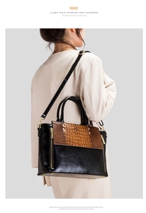 Détail d'un sac à main noir et marron à motif crocodile avec finitions dorées