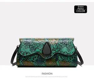 Detail view of green peony embossed pattern on ethnic style leather crossbody bag