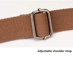 Détail de la bandoulière en toile marron réglable avec boucle en métal gris foncé