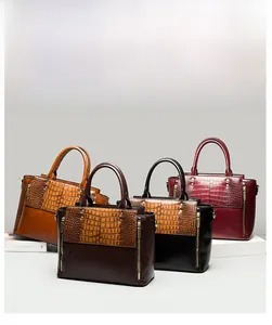 Détail de quatre sacs à main en cuir croco en marron, café, noir et bordeaux