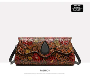 Macro detail of ethnic floral embossed leather bag with yellow peony pattern and clasp