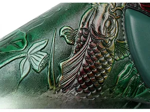 Detailed close-up of dark green embossed leather with traditional koi fish and lotus patterns