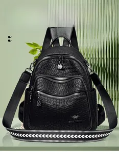 Detail of black faux leather backpack featuring lychee texture and geometric V-pattern strap