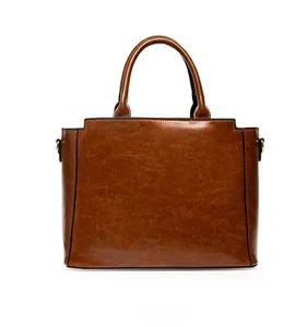 Détail du sac à main effet crocodile avec poignées robustes et boucles métalliques latérales