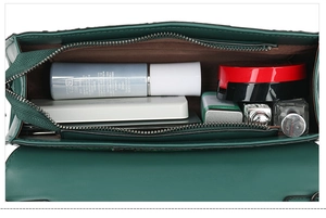 Interior view of dark green crossbody bag showing main compartment and storage capacity