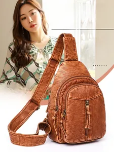 Macro detail of retro brown washed leather texture and multi-zipper compartments on chest bag