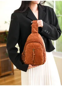 Close-up of vintage brown washed leather sling bag with multiple functional zippers