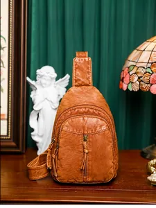 Macro shot of retro brown washed PU leather crossbody bag featuring fringe zipper details
