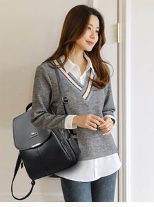 Detailed view of black pebbled leather backpack with silver kangaroo logo and texture