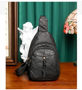 Detailed view of black PU leather chest bag with multi-zipper pockets and vintage texture