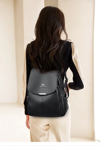 Close-up of black lychee-textured leather backpack with silver kangaroo logo on model