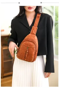 Detail view of a vintage brown washed leather crossbody chest bag worn by a model