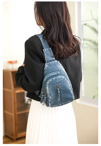Detail view of a blue vintage PU leather chest bag showing texture and zipper pockets