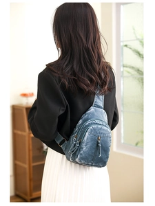 Vintage blue washed leather chest bag with zipper detail on a female model