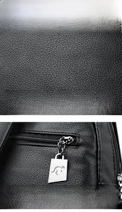 Macro view of black lychee grain leather texture and metal kangaroo logo zipper puller