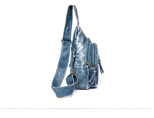 Side view detail of blue washed leather crossbody bag with triple zipper pockets