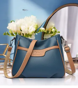 Detail of lychee texture leather shoulder bag with kangaroo logo and wide strap