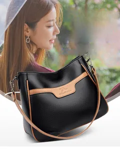 Detail of black and brown color-block crossbody bag with pebbled leather and logo stamp