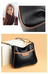 Detailed view of black litchi texture leather crossbody bag with brown contrast trim