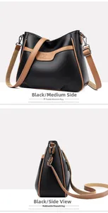 Detail view of black lychee leather crossbody bag with brown trim and metal zipper