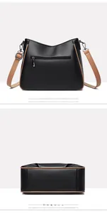 Detail view of black pebble leather crossbody bag showing back zipper and flat base