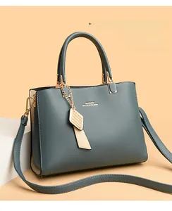 Détail du sac à main vert Morandi avec logo doré et bandoulière amovible élégante
