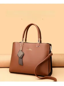 Sac à main en cuir litchi marron avec détails dorés et pendentif géométrique carré