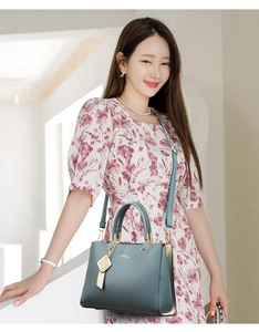 Détail d'un sac à main bleu en cuir porté avec une robe à fleurs pour femme