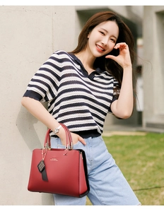 Sac à main chic en cuir rouge et noir présenté par un mannequin dans un décor urbain