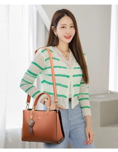 Sac à main en cuir marron porté par le mannequin avec détails dorés et bandoulière