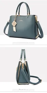 Détail du sac à main en cuir bleu sarcelle avec côtés beiges et pendentif métallique