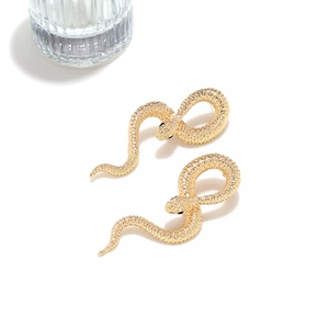 Vue macro détaillée de boucles d'oreilles serpent dorées avec textures d'écailles et courbes en S