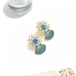 Detail of teal enamel shell earrings with golden ribs and blue crystal studs