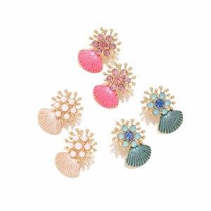 Detailed macro view of three pairs of colorful enamel shell earrings with vibrant gemstones
