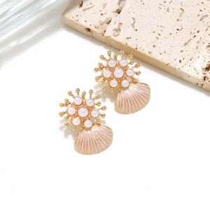 Detail of gold shell earrings with pink enamel, faux pearls and starburst studs