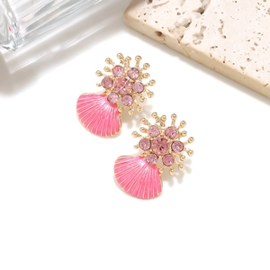 Macro shot of pink enamel shell earrings with gold flower details and pink crystals