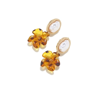 Macro shot of baroque pearl stud with leopard print resin flower pendant earrings