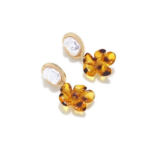 Detail of baroque pearl and amber leopard print flower drop earrings with golden frame