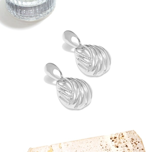 Macro shot of silver hollow geometric earrings with micro-inlaid rhinestones and texture