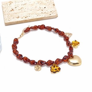 Détail d'un collier vintage avec pendentif cœur léopard et fleur en résine ambrée créative