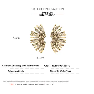 Detail view of large gold vintage leaf earrings with rhinestones measuring 7.3x4.3cm