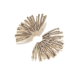 Detailed shot of golden sunburst leaf earrings encrusted with sparkling rhinestones