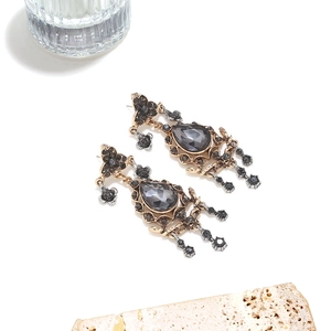 Detailed close-up of Baroque vintage drop earrings with crystals on stone stand