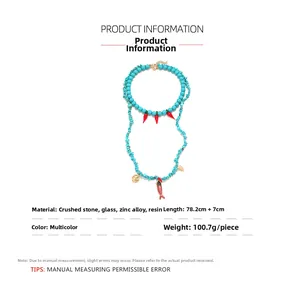 Detail view of turquoise beads and red chili charm necklace with size and material info